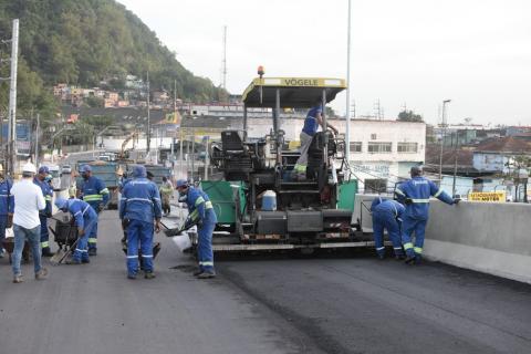 Homens e máquina trabalhando na pavimentação. #Paratodosverem