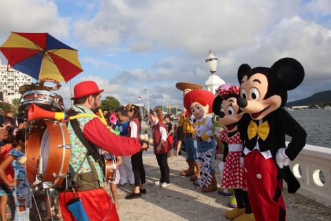 Personagens do Mickey e Toy Story, além de palhaços posam para fotos no calçadão. #Pracegover