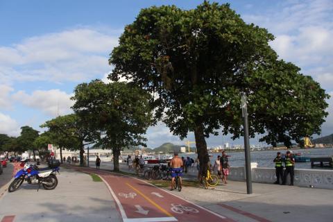 Vista geral de trecho de calçadão, com pistas para pedestres e ciclovias Muretas típicas de Santos ao lado direito e de frente para o mar. #Pracegover