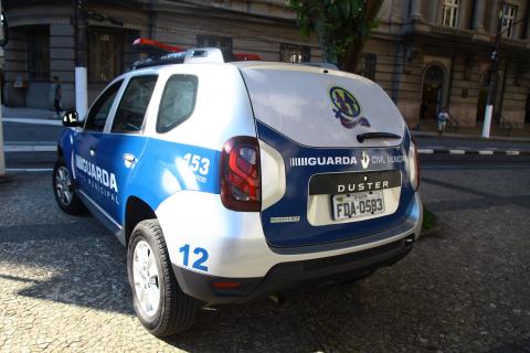 Viatura da Guarda Municipal adesivada e com o selo do programa Guardiã Maria da Penha na porta do bagageiro. #Pracegover