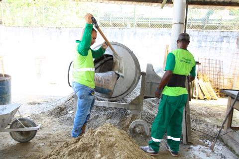 Material para formação do concreto é despejado em betoneira para homogeneizar. #Pracegover