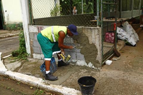 operário faz manutenção em muro #pracegover 