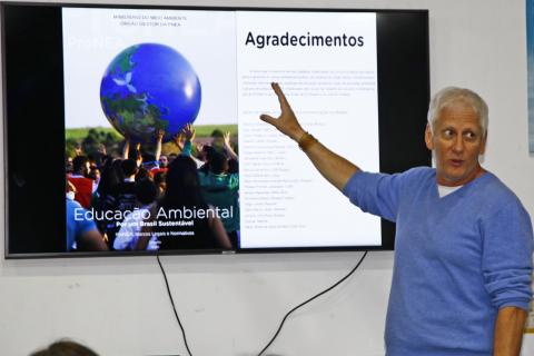 especialista aponta para telão onde há globo azul #pracegover