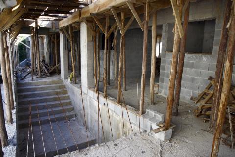 Obra de escola com escadaria aparente na área interna e vigas provisórias de sustentação. #Pracegover