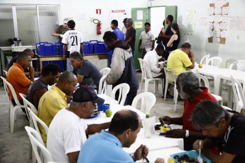 pessoas comendo na mesa de abrigo #pracegover 