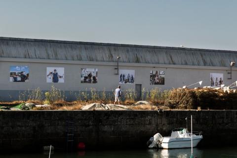 Painéis fixados em grande muro de área portuária. #Paratodosverem