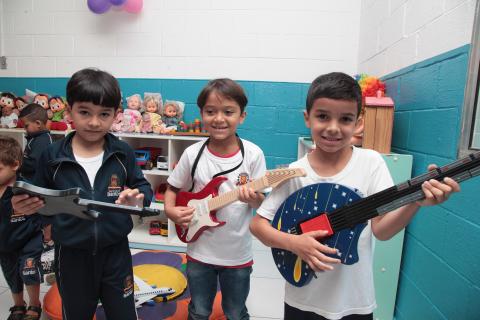 crianças brincam com guitarras de brinquedo #pracegover 