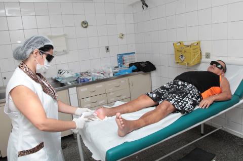 enfermeira trata ferida em pé com laser #pracegover 