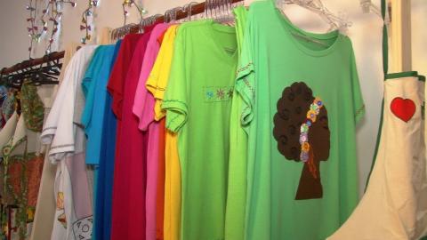 Camisetas customizadas penduradas em cabides. #Paratodosverem