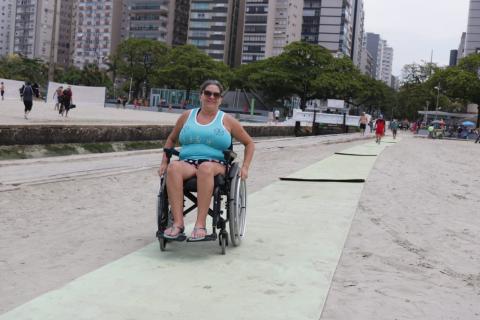 Cadeirante anda em esteira na faixa de areia. #pracegover