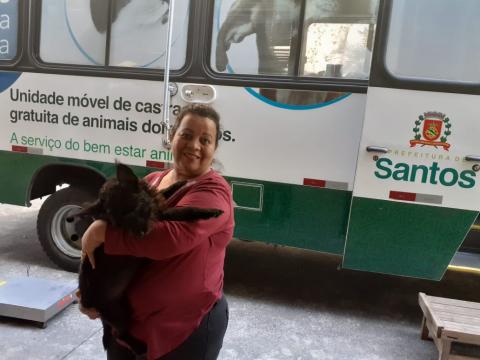 doma abraça cachorro ao lado do castramóvel #pracegover 