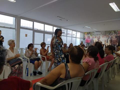 idosa desfile acompanhada por outras #pracegover