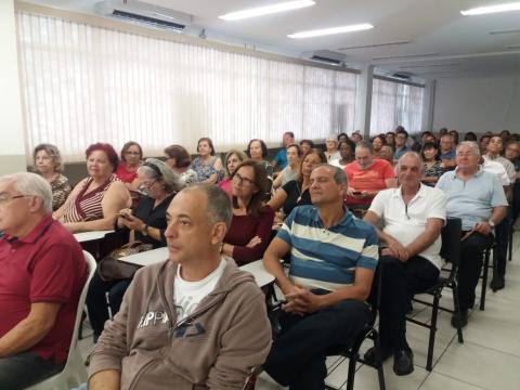 Os formandos sentados em auditório. #Pracegover