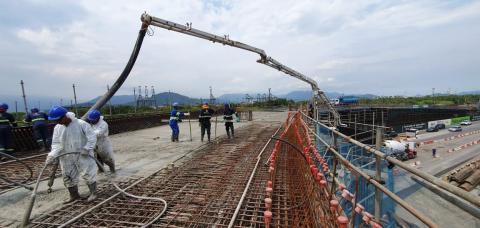 operários utilizam máquina na concretagem #pracegover 