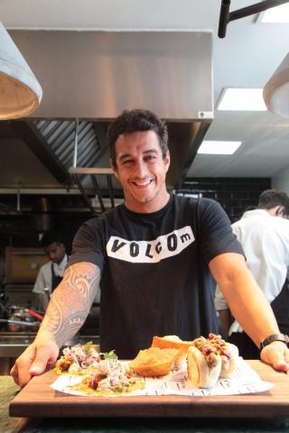 O chef Dario  Costa segura bandeja com vários pratos de comida. #Paratodosverem