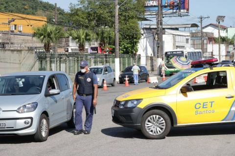 Guarda Municipal se aproxima de veículo na via. Ao lado direito está uma viatura da CET. #Paratodosverem