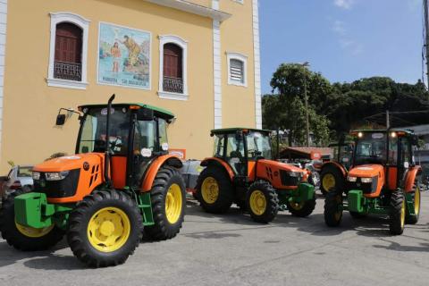 3 tratores parados ao lado de igreja #paratodosverem 