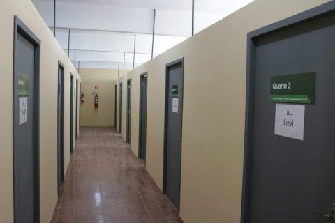 #pracegover foto mostra corredor vazio com portas numeradas
