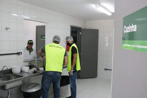 #pracegover três homens uniformaizados manuseiam equipamentos em pia de cozinha