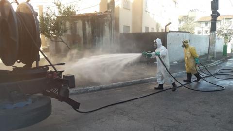 atrás de caminhão, dois homens limpam calçada #paratodosverem 