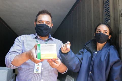 pessoas mostram caixa e dose da vacina #paratodosverem 