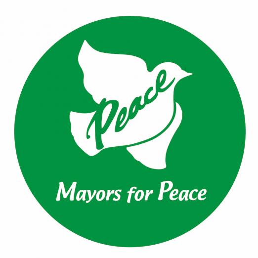 O logotipo da Mayors for Peace, com uma pomba ao centro e a palavra Peace. #Paratodoslerem