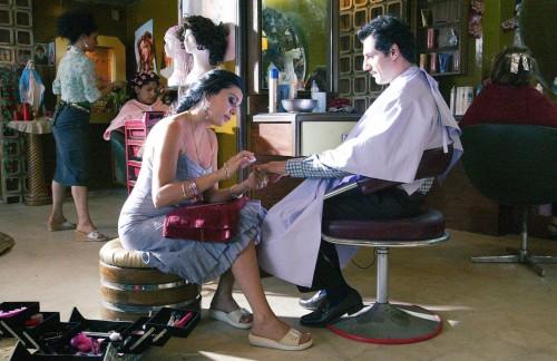 Mulher sentada faz a unha de homem em um salão de beleza. #paratodosverem