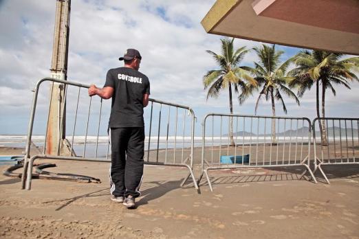 homem coloca cavalete para fechar a praia #paratodosverem 