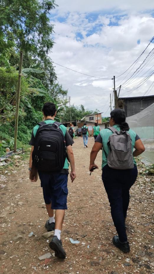 agentes uniformizados caminham por rua de terra. #paratodosverem 