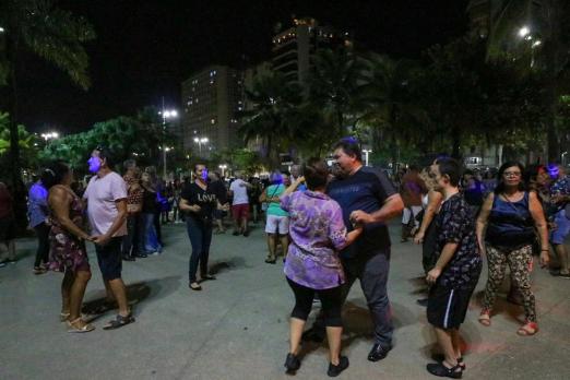 pessoas dançando no baile na praia #pracegover 