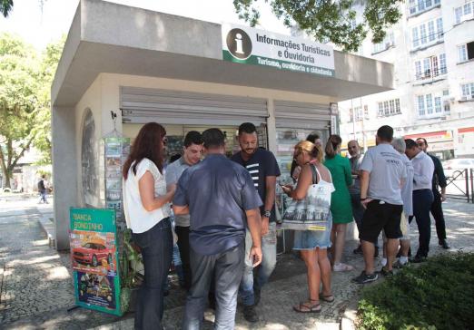 pessoas na frente de banca de jornal #paratodosverem 
