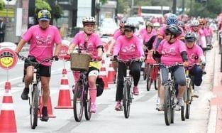 Pessoas andando de bicicleta de rosa #paratodosverem