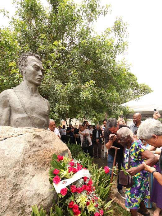pessoas depositam flores no busto #paratodosverem