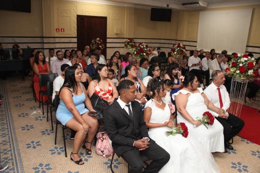 casais e convidados sentados na cerimônia do casamento comunitário #paratodosver