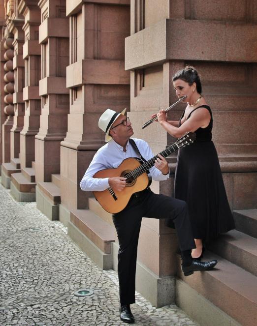 homem toca violão olhando para mulher #paratodosverem