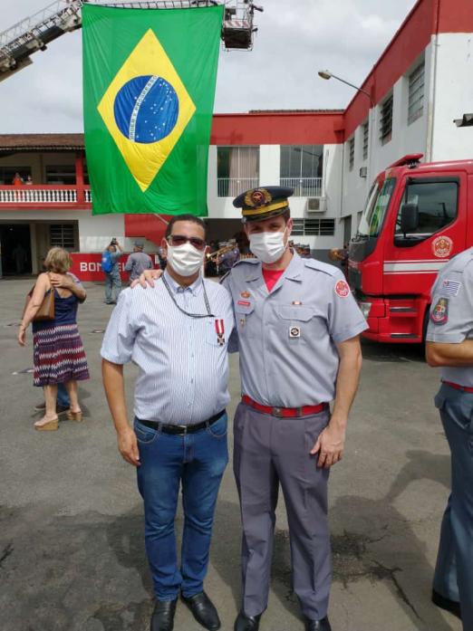 servidor posa ao lado de bombeiro #paratodosverem 