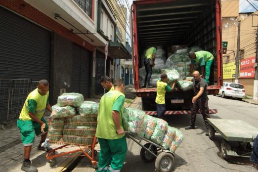 homens colocam doações em caminhão #paratodosverem 