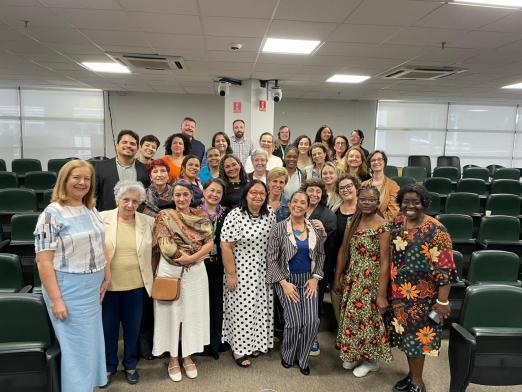 Pessoas posam para foto em auditório #paratodosverem