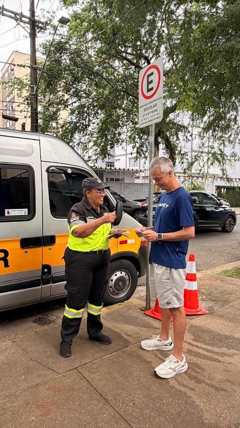 agente entrega panfleto a homem sentado #paratodosverem