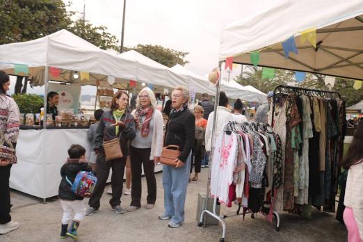 pessoas andando em meio a barracas #paratodosverem