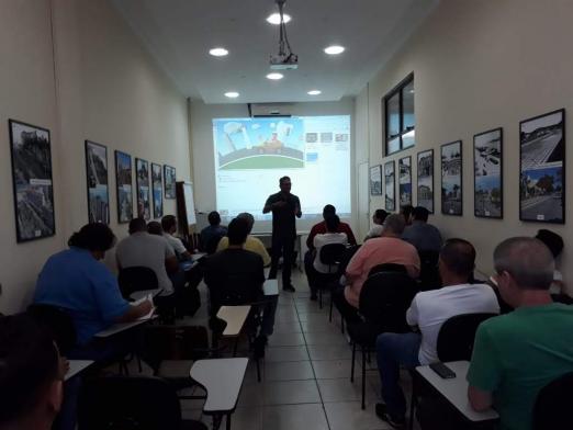 Alunos assistem ao curso com imagem em telão #paratodosverem 