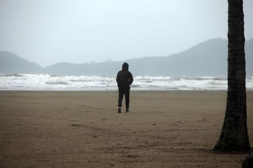 pessoa agasalhada sozinha na praia. #paratodosverem