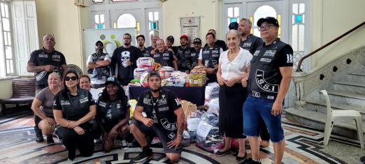 integrantes de grupo posam com produtos #paratodosverem