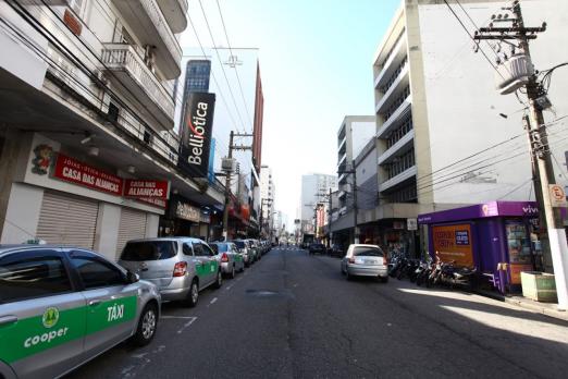 Rua do Gonzaga com veículos e estabelecimentos de portas fechadas. Imagem de arquivo. #Paratodosverem