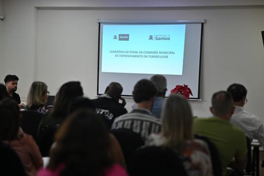 pessoas reunidas em sala vendo telão #paratodosverem 