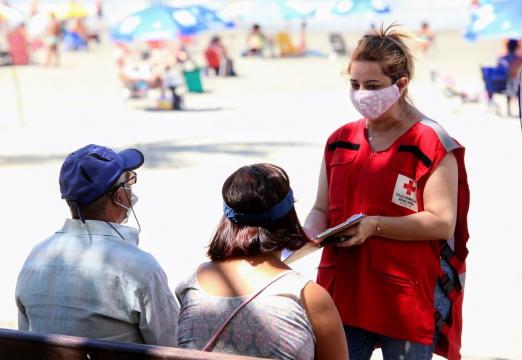 voluntária fala com duas pessoas #paratodosverem