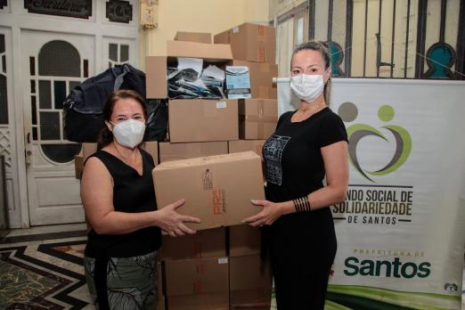 mulheres seguram caixa com doação #paratodosverem 