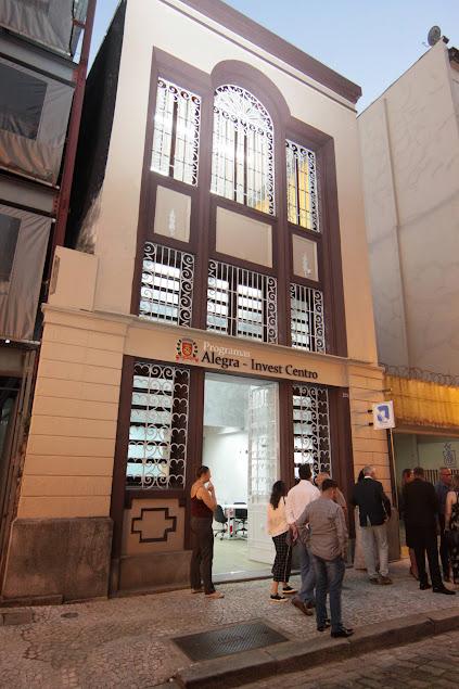 fachada do prédio onde funcionará o escritório, com pessoas na calçada. #paratodosverem