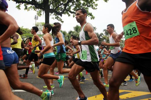 Pessoas estão correndo em avenida. #Pracegover