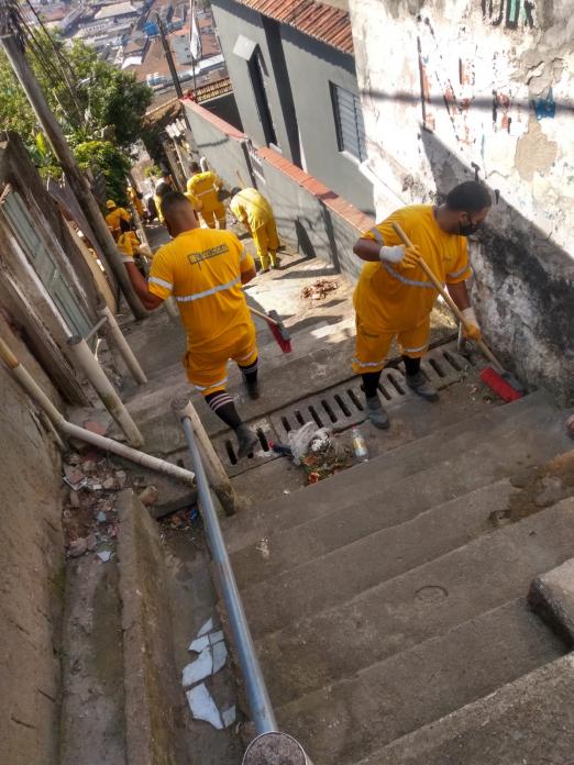 Homens limpando escadaria em morro. #paratodosverem